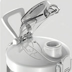 Gros plan sur un distributeur d’eau blanc avec couvercle transparent sur fond gris clair
