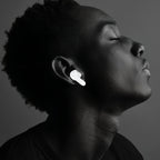 Personne portant des Korons Écouteurs de Traducteur sur fond sombre