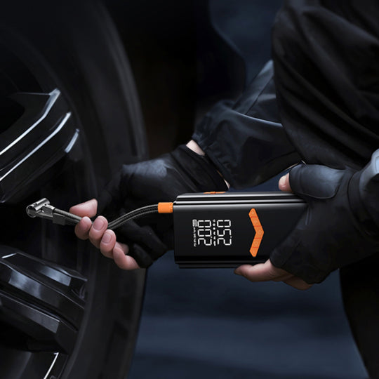 Personne utilisant un nomade Gonfleur de Pneu & Booster de Batterie Voiture Portable 2-en-1 sur un pneu de voiture